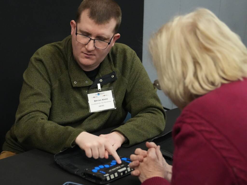 Bryan Ward demonstrating a braille display to other professionals