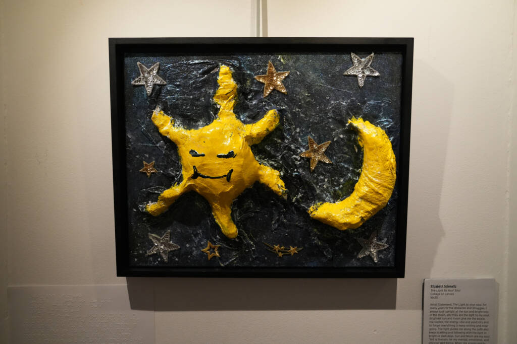 Artwork on a wall - a yellow raised tactile interpretation of the sun and moon.  