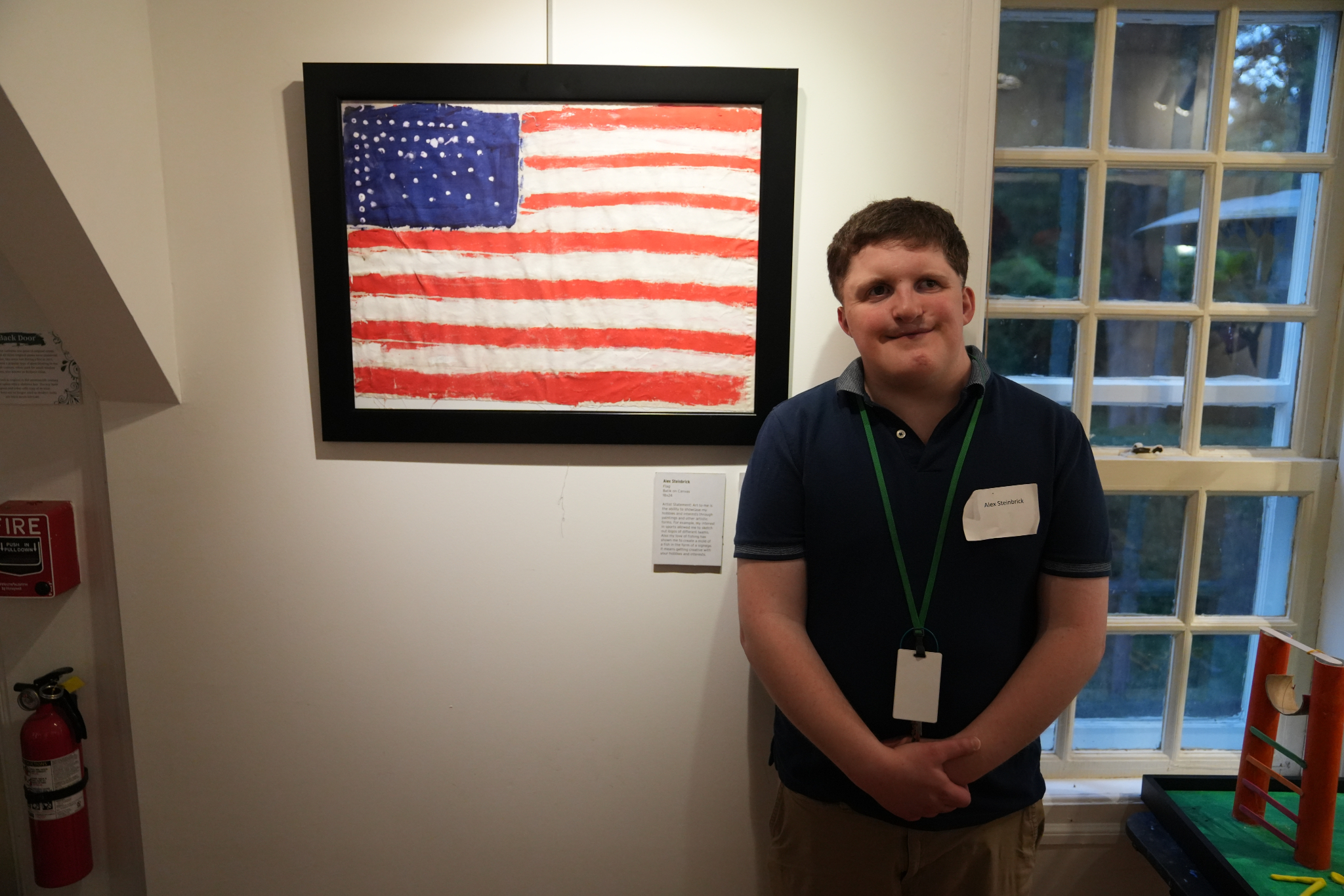 An HKNC participant stands proudly next to his painting of an American Flag.