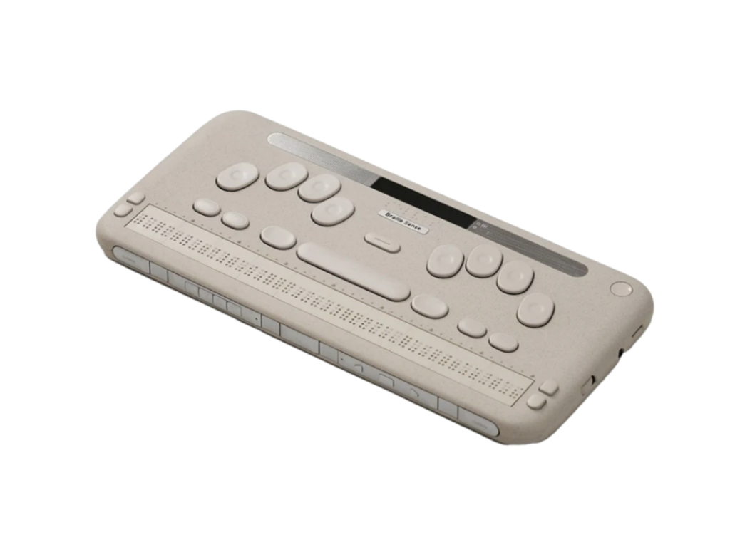 The Selvas BrailleSense 7, an angled view of a cream-colored braille notetaker with a Perkins-style keyboard, command keys, and a braille display along the front edge.