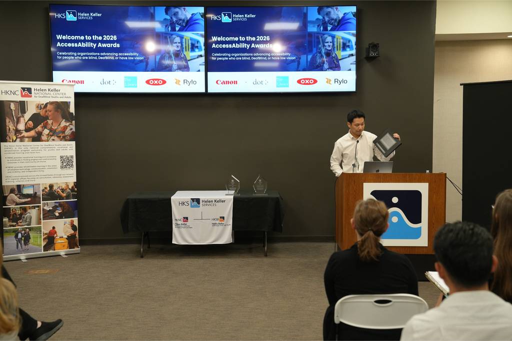 Dot Inc.’s co-founder holds up a Dot Pad at the podium.