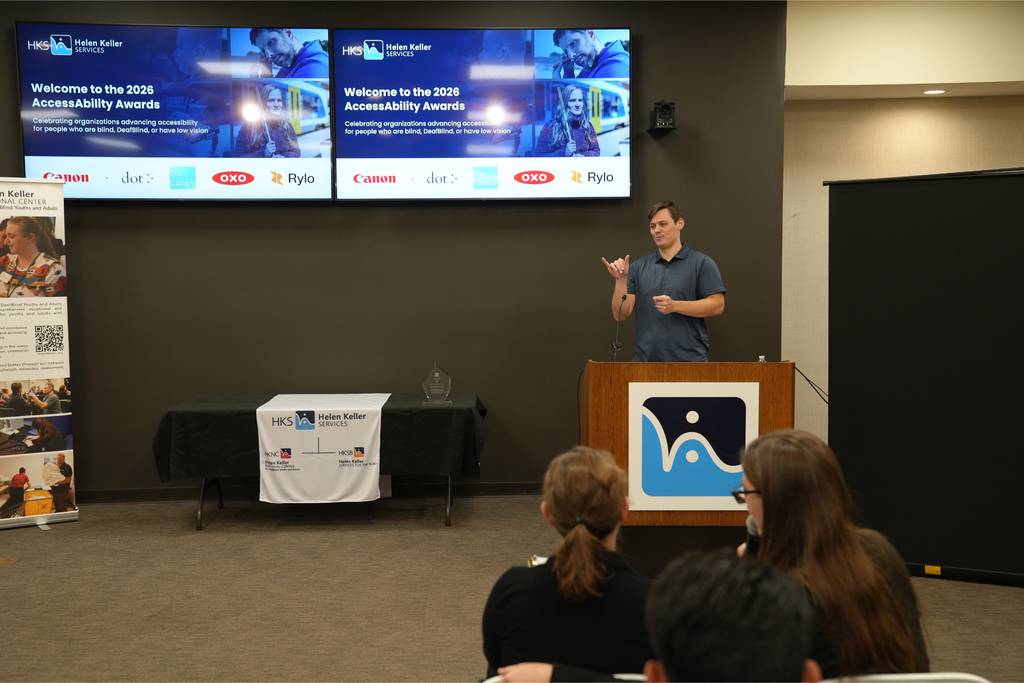 Rylo’s Head of Community signs his remarks at the podium.